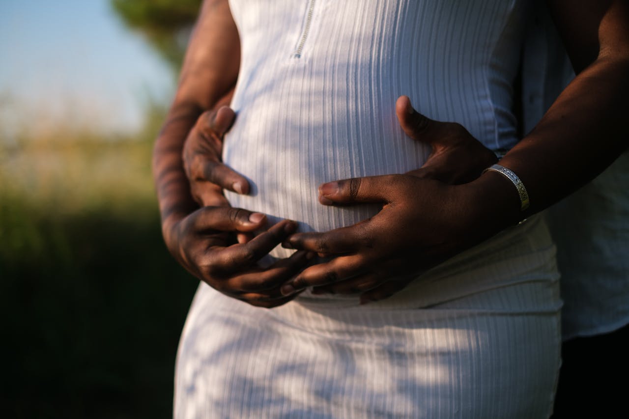 Man holding her pregnant wife's stomach.