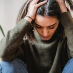Woman having a headache and holding her head.