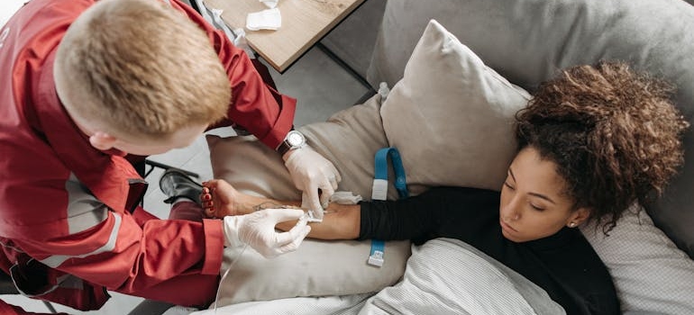 Woman receiving an IV from a medical professional.