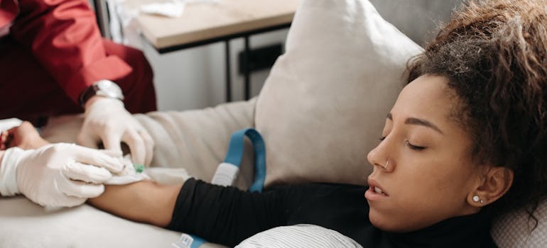 Woman receiving an IV while lying in bed.