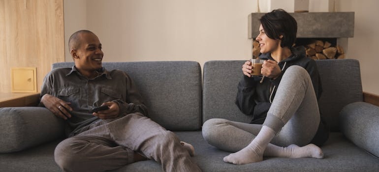 Couple sitting on the couch and having a serious conversation.