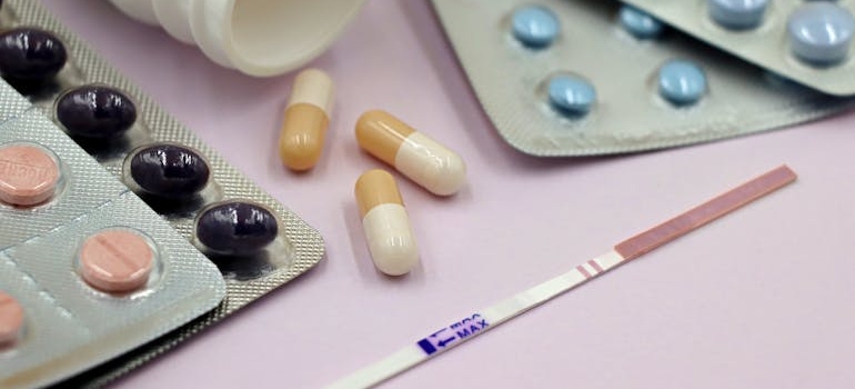 Positive fentanyl test strips next to blisters of pills.