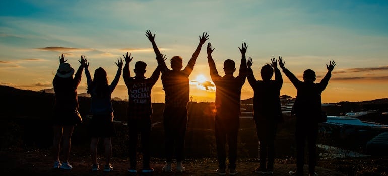 Silhouettes of people looking at the sun.