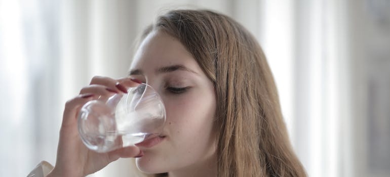 Woman drinking water while going through Trazodone withdrawal.
