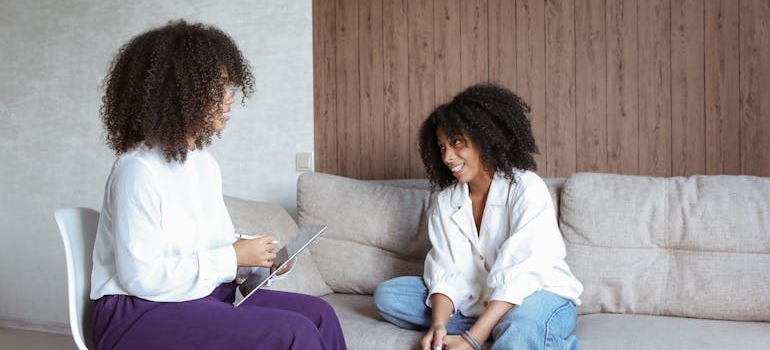 Woman sitting on a couch and talking to her therapist.