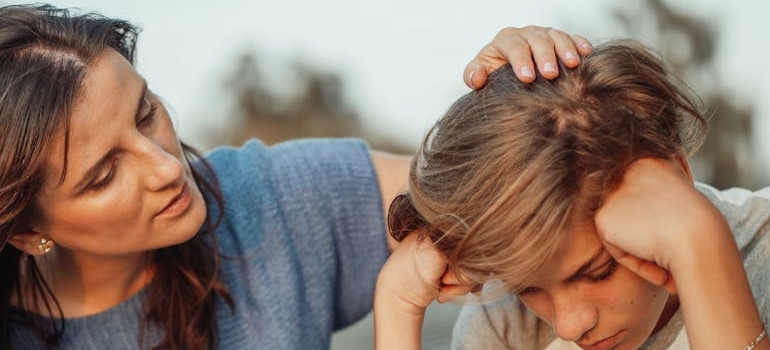 Woman talking to a sad teenager.