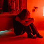 Woman sitting on the bathroom floor worrying about how to tell if someone is using cocaine.