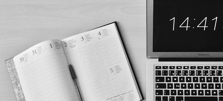 Planner next to a laptop clock.
