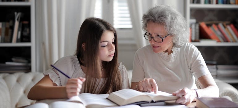 Older women studying with her granddaughter after learning how to protect a grandchild from a drug addicted parent.