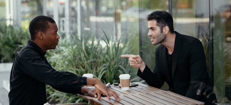 Two men drinking coffee and having a conversation.