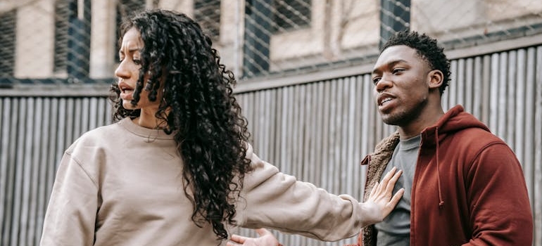 Woman pushing away her boyfriend during an argument.