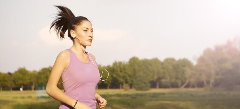 Woman jogging with earphones in her ears.