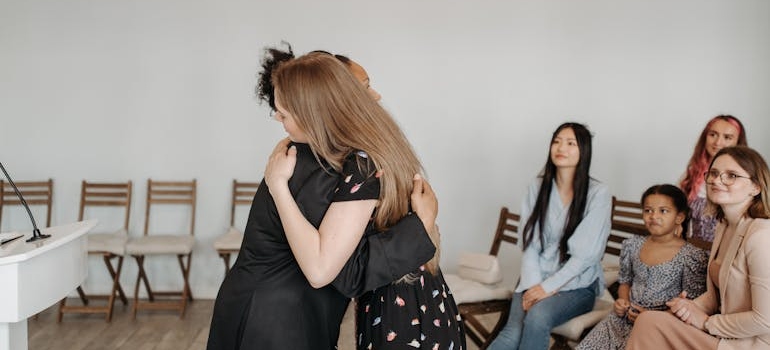 Women hugging each other in a support group meeting.