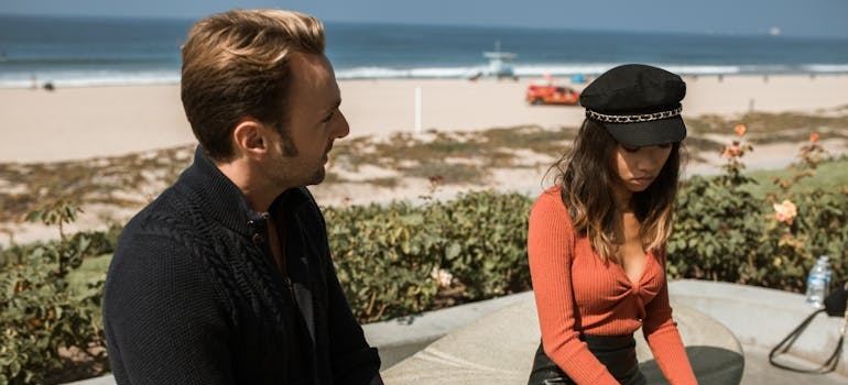 Couple sitting near a beach after an argument.