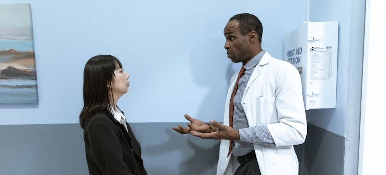 Doctor talking to a rehab representative about how to transfer from one rehab facility to another.