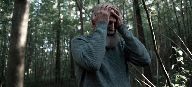 Older man having a panic attack in the woods.