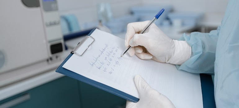Doctor writing in a medical chart.