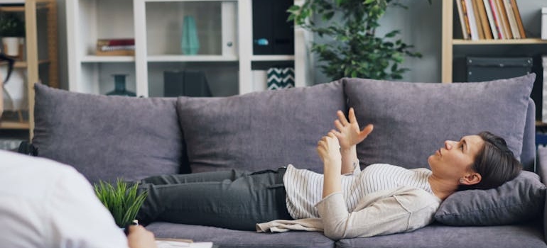 Woman lying on the couch while talking with her therapist.
