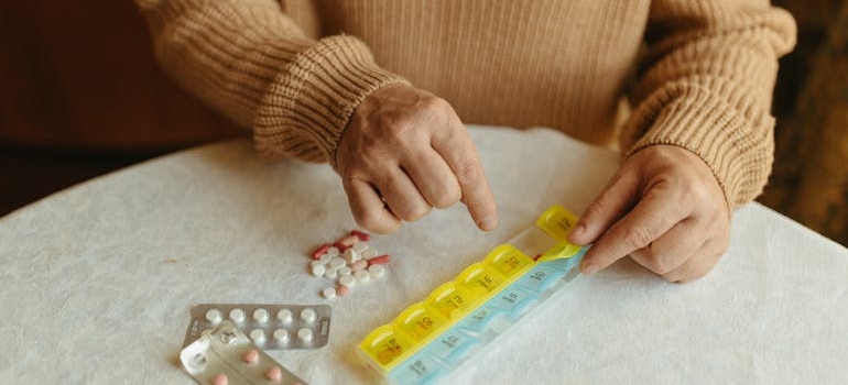 Woman counting pills in her pill container.
