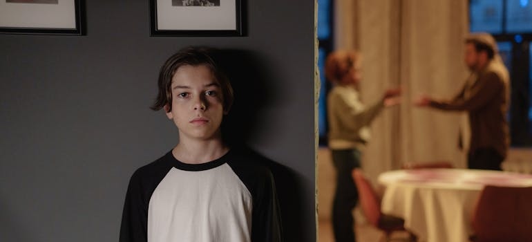 Adolescent boy listening to his parents fighting.