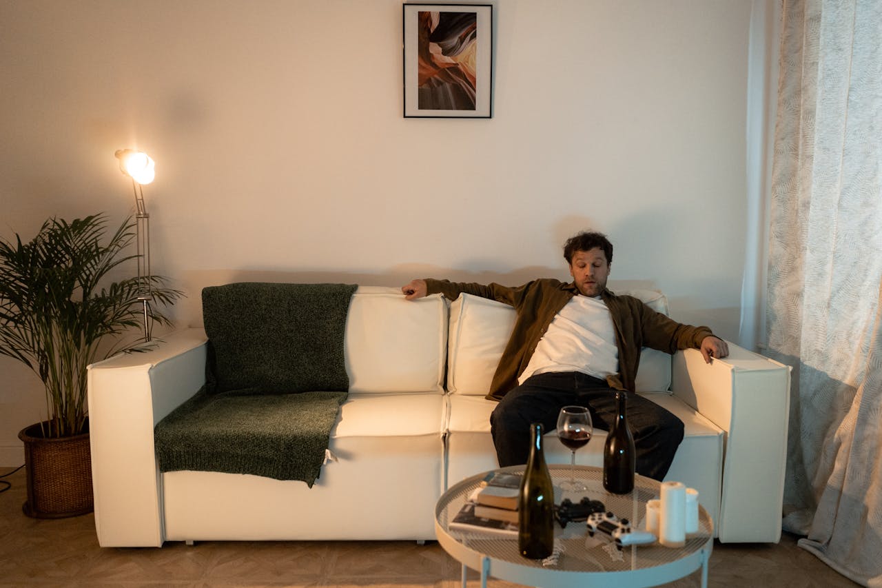 Man sitting on the couch after drinking wine.