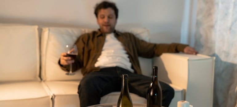 Man sitting on the couch and drinking a glass of wine.