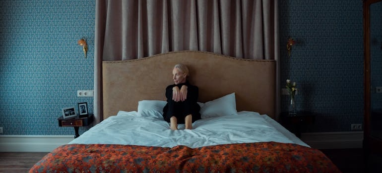 Woman sitting on the bed alone and struggling with depression in the elderly.