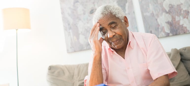 Older man having a headache while struggling with depression in the elderly.