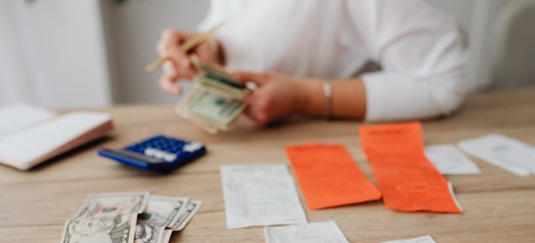 Woman counting money while calculating her budget.