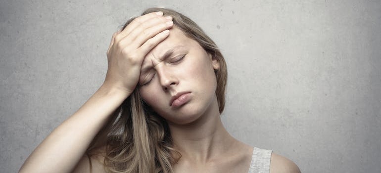 Woman holding her head while having a headache.