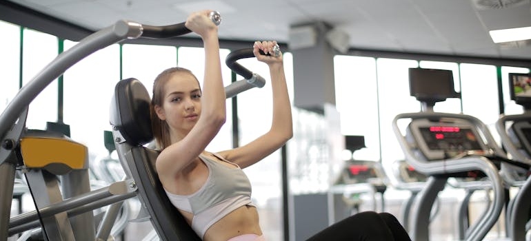Woman exercising on gym equipment.