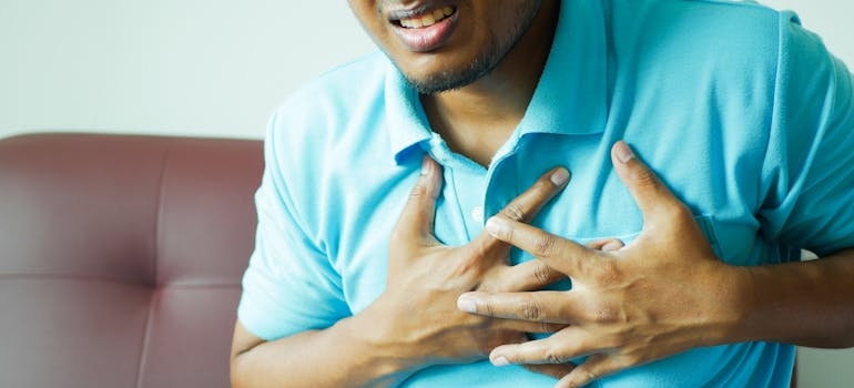 Man holding his chest while suffering with chest pain.