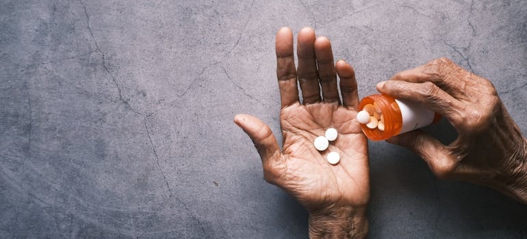 Older person pouring pills into their hand.