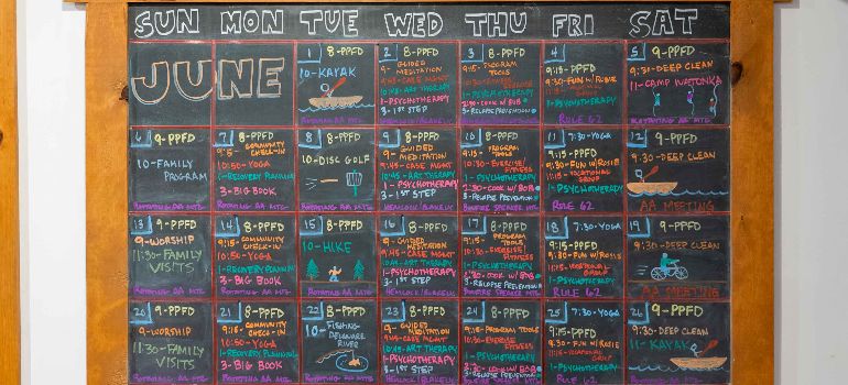 A blackboard with little creek schedule by days written on it