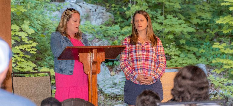 a group therapy session where two women stand on podium