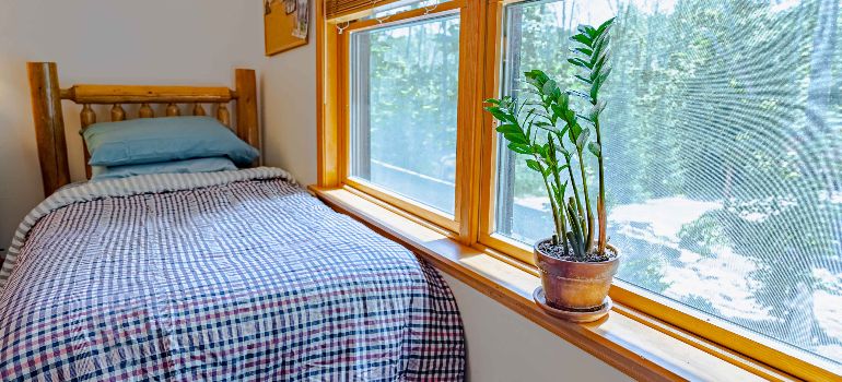 a bed near the window at the residential facility