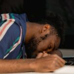a man slumped over a desk, unable to keep awake which is one of the fentanyl abuse signs