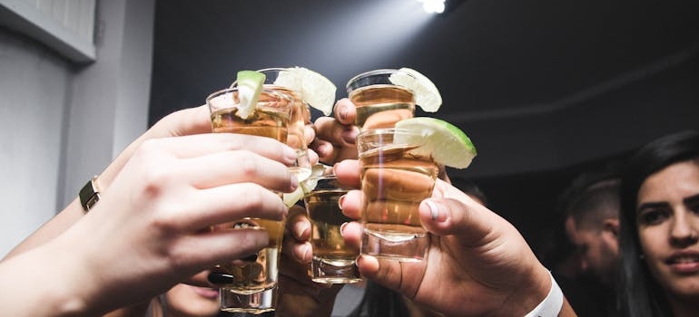 People toasting with shots of alcohol at a party.