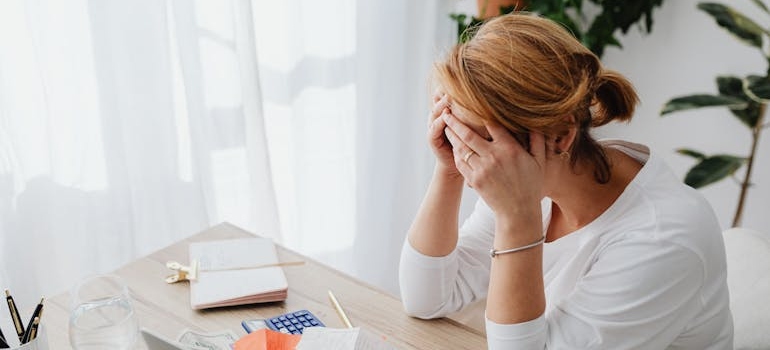 Woman crying while worrying about bills and financial problems.
