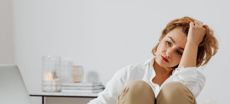 Woman crying while thinking about the signs and symptoms of heroin use.