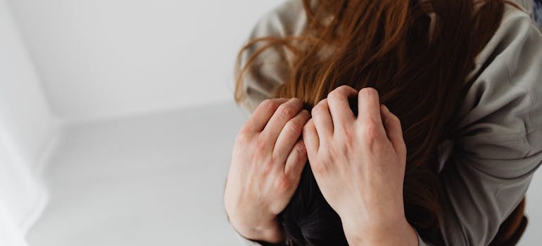 Woman covering her while sitting on the chair.