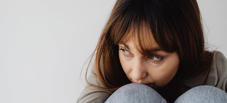 Woman leaning her head on her knees.