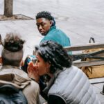 People spreading gossip with drug addiction stereotypes about a man in front of them.