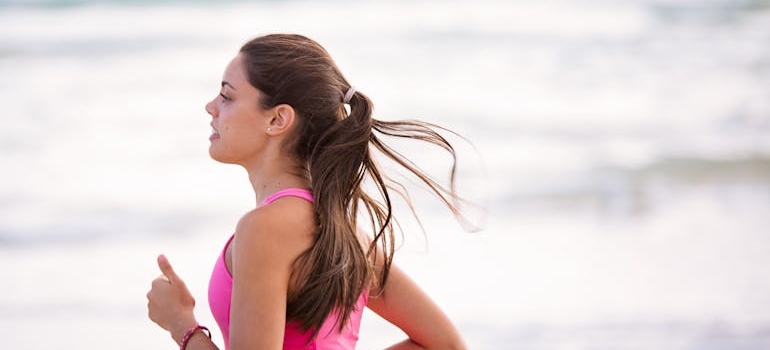 Woman jogging alongside the beach because boredom triggers relapse.