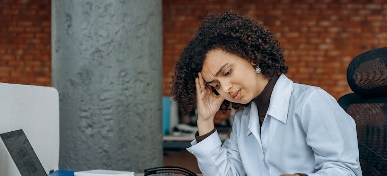 Woman with burnout looking at her laptop.