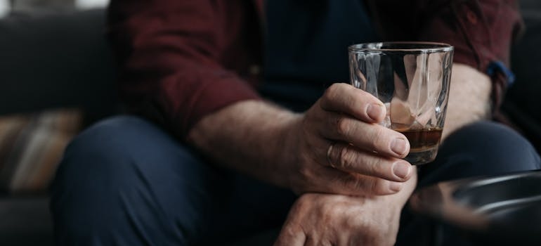 Man holding a glass of whiskey.