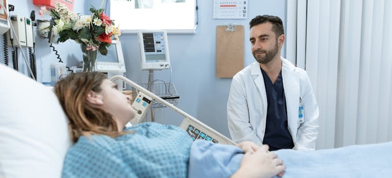 Doctor talking about the risks of quitting alcohol cold turkey to a patient who is in a hospital bed.