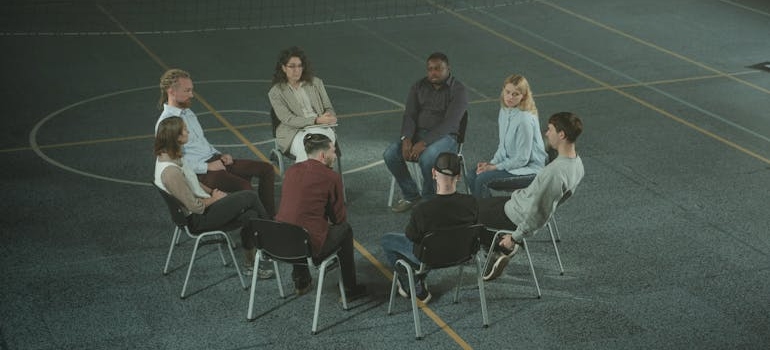 People in a peer support group sitting in a circle while talking about quitting alcohol cold turkey.