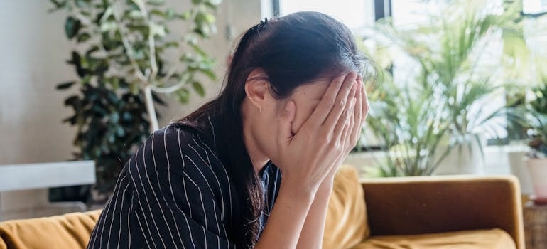Woman covering her face while crying.