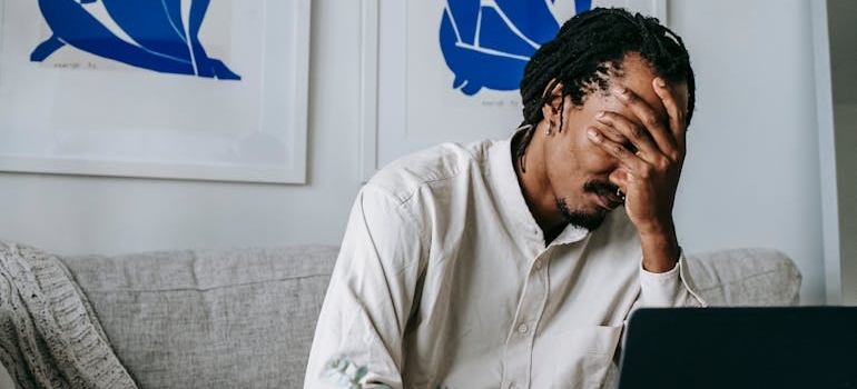 Man covering his face with his hand while worrying about how to tell if someone is using methadone.